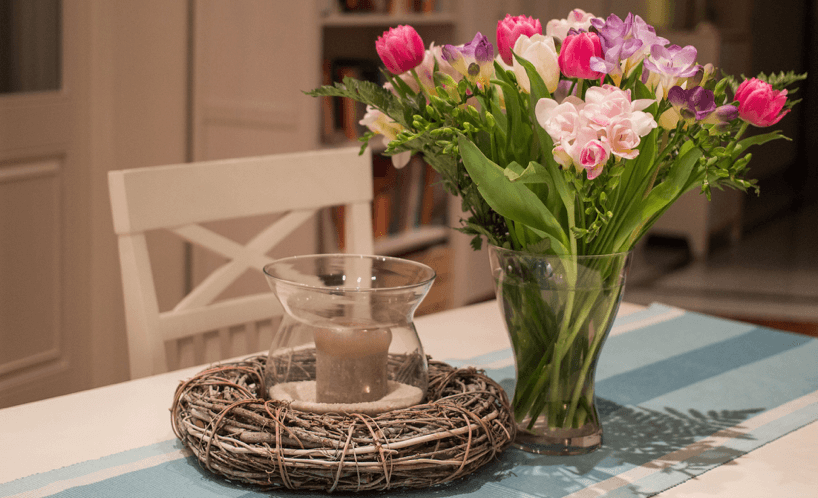 tisch-mit-blumenvase-und-windlicht-im-landhausstil